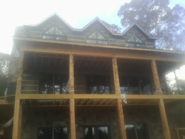 Dormers and porch framing on a large log home under construction — Roof Coating work by our crew in Wellpinit